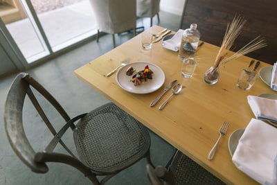 白色的陶瓷板和银餐具在桌子上
